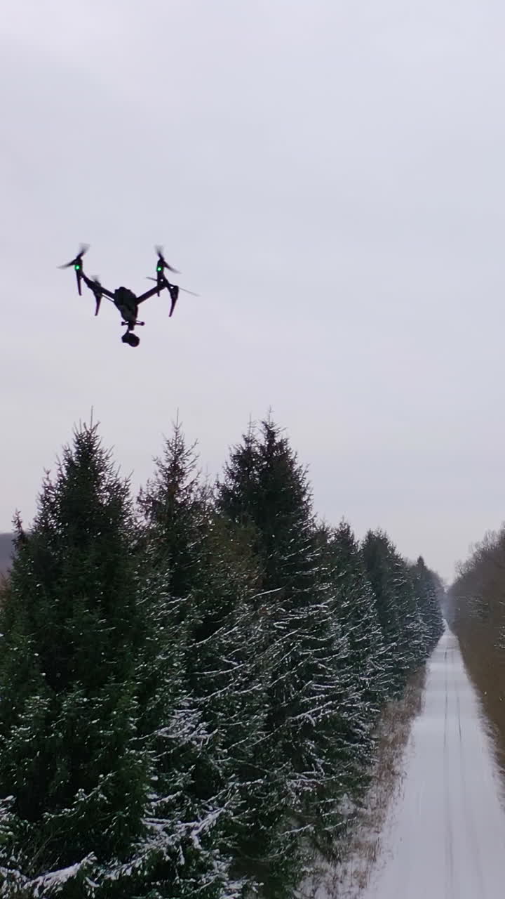 Drone with camera flying high above. Personal drone flying through the air in suburban atmosphere