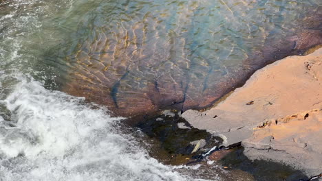 view looking down natural waterfall feeding into river