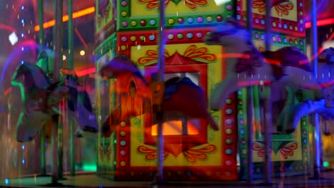 horses going around a carousel in an amusement arcade at a fairground carnival