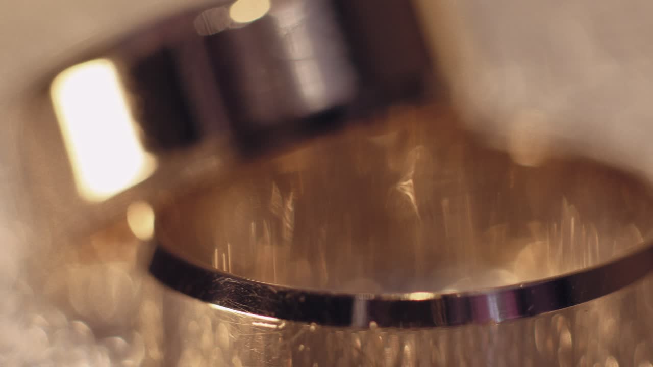 Wedding gols rings lying on shiny glossy surface. Shining with light. Close-up