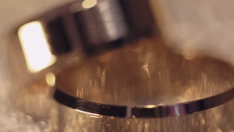 los anillos de bodas se encuentran en una superficie brillante y brillante, brillando con luz.