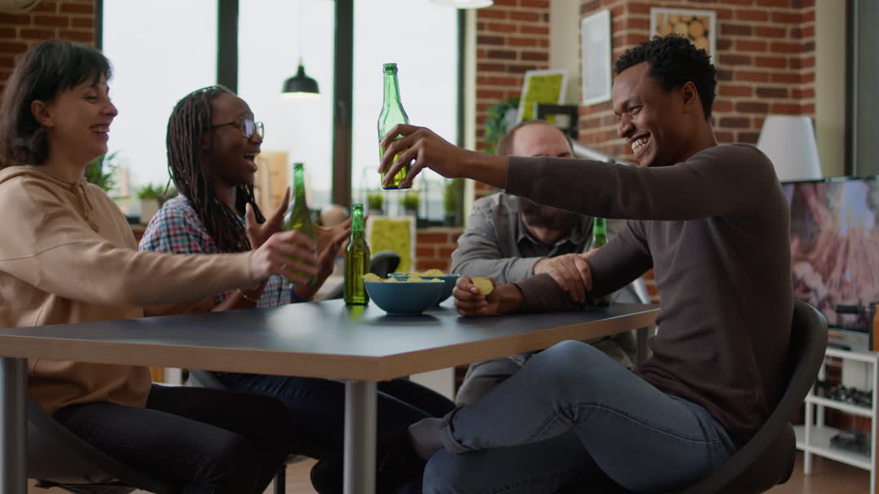 Cheerful people laughing and doing cheers gesture with beer