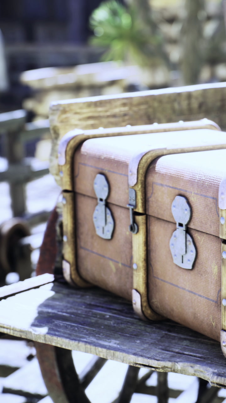 Two antique wooden trunks sit side by side on a rustic wooden bench