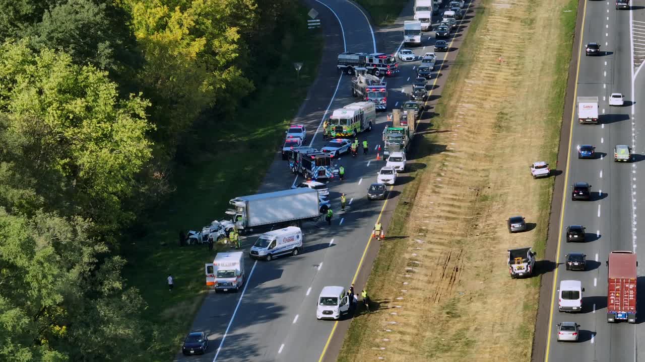 Sad accident scene on american highway during sunset time in autumn.Traffic jam after car crash.Destroyed truck and car.Police, Ambulance and Firefighter work and help injured people. Aerial view.