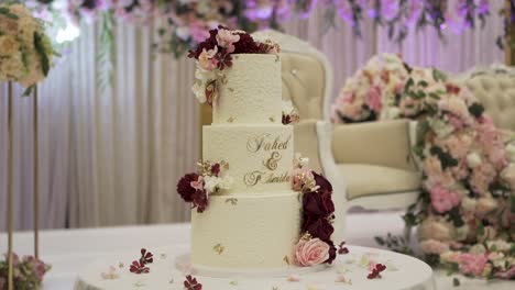 a detailed examination of a beautifully decorated wedding cake in the venue hall.