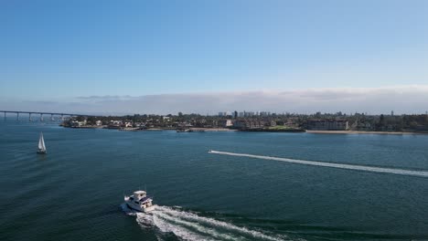 boats cruising on san diego bay with view of coronado bridge in distance