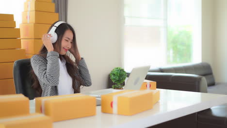 While-taking-a-break-from-work-a-young-woman-listens-to-music-and-dances-at-her-desk