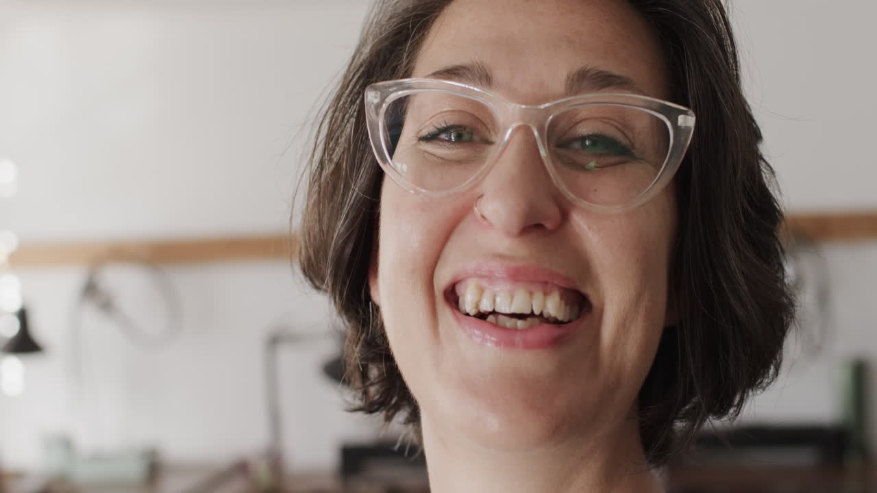 retrato de una feliz trabajadora caucásica con gafas en un estudio de joyas en cámara lenta.