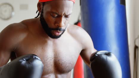 Male-boxer-in-aggressive-mood-in-fitness-studio-4k
