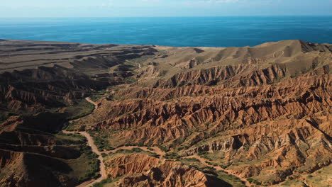 wide drone shot of fairy tale canyon and issyk-kul lake in karakol, kyrgyzstan