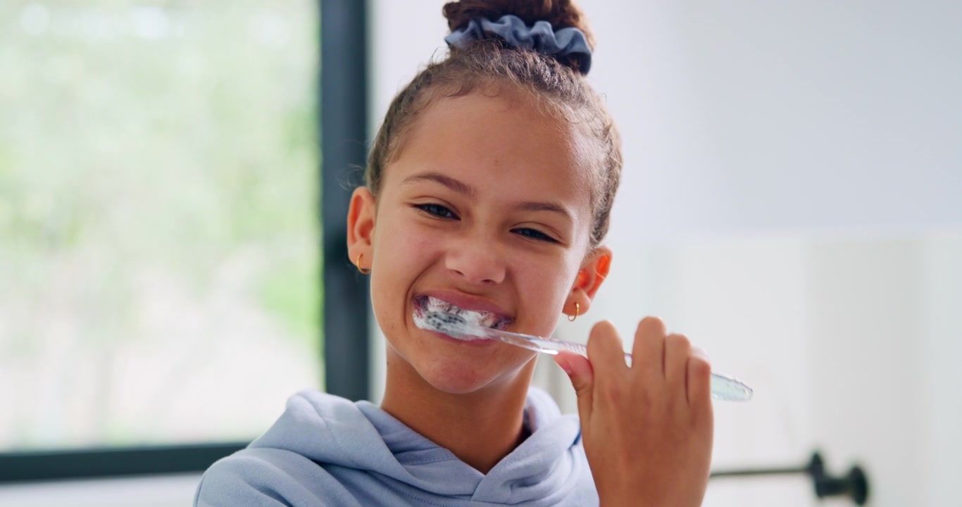 Young Girl Brushing Her Teeth in the Bathroom