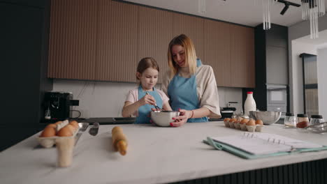 Fröhliche-Frau-Und-Kleines-Mädchen-Kochen-Teig-In-Der-Küche.-Mutter-Und-Tochter-Verbringen-Zeit-Miteinander-Zu-Hause