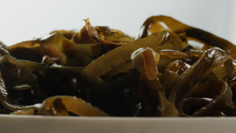 japanese wakame chuka fermented food. close-up on a detail of hiyashi wakame chuka or seaweed salad or seaweed with sesame seeds on a plate. top view. seafood background. health concept.