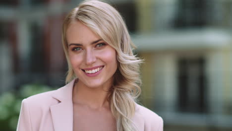 Portrait-happy-businesswoman-looking-into-camera.-Woman-smiling-at-street