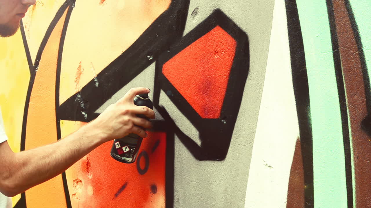 L'artista disegna graffiti su una recinzione. Graffiti su una recinzione.
