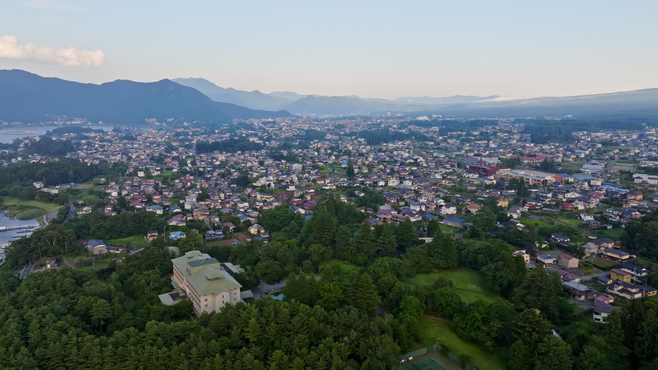 Panoramic drone shot around the cityscape of Kawaguchiko, summer sunrise in Japan