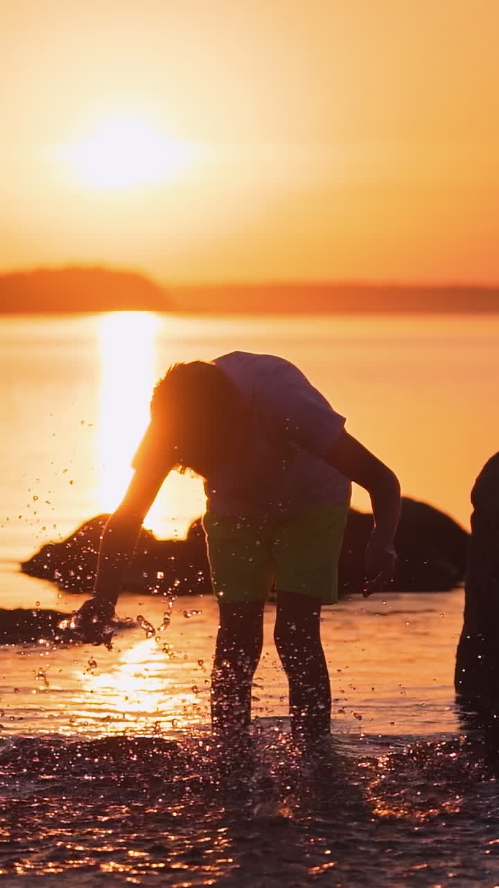 Boy near water pond. Silhouette of boy enjoying life near the pond Vertical video