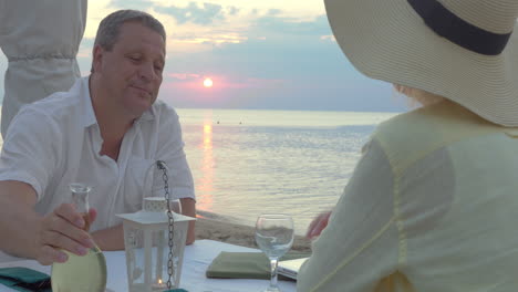 una pareja madura disfrutando de la noche en la orilla del mar.