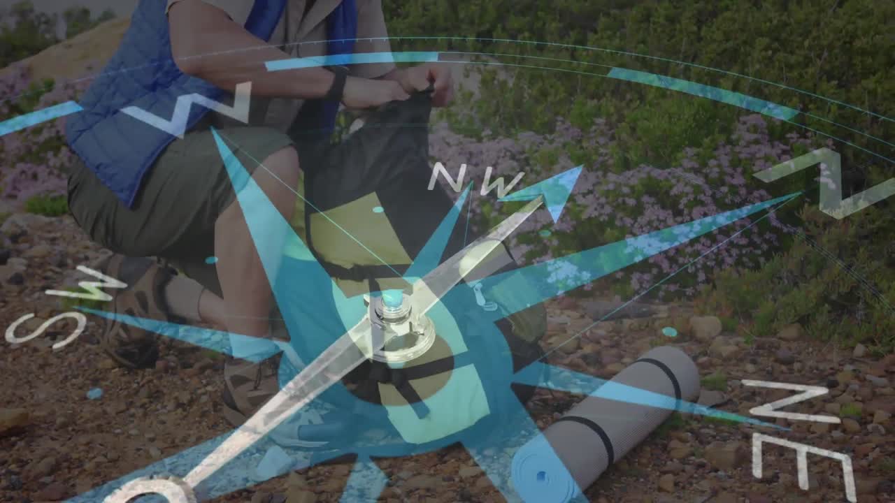 백인 장년 남자가 시골에서 하이킹을 하고 배 ⁇ 에서  ⁇ 안경을 꺼내서 나침반을 돌리고 있습니다.