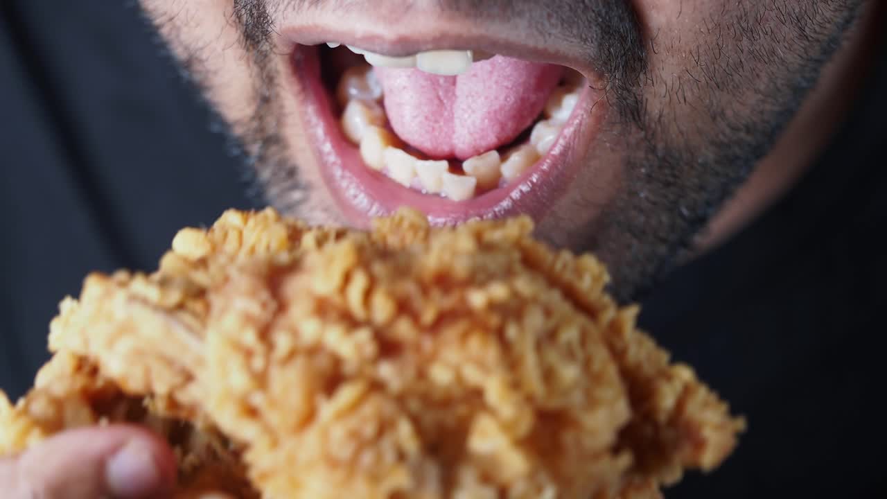 Close-up of a man eating fried chicken