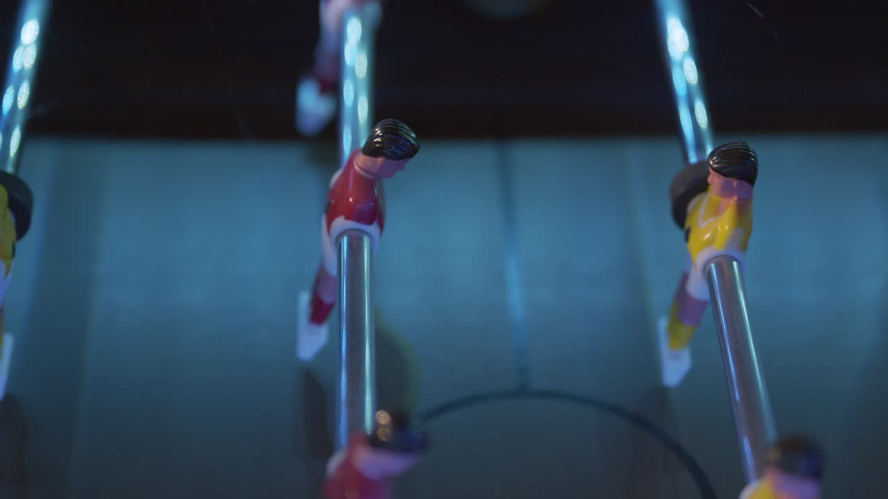 Foosball table game shot in a left to right medium speed, close up, tracking shot