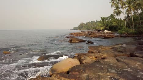 un dron lento disparó sobre rocas golpeadas por las próximas olas del océano, koh kood tailandia