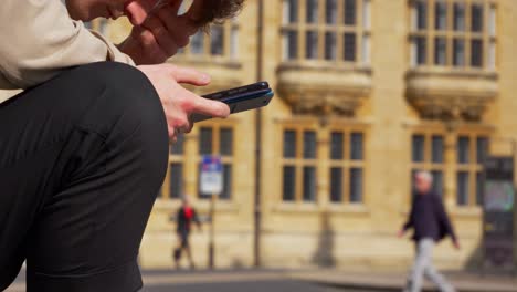 Nahaufnahme-Eines-Mannes,-Der-Das-Telefon-Auf-Der-Alten-Straße-In-Oxford-02-Ansieht?