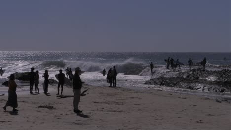 group of surfers standing at beach with waves splashing. snapper rocks in coolangatta, qld, australia. wide shot