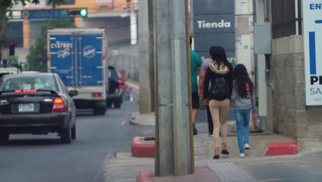 slow motion street view of people walking along the street and cars passing by in zone 18, guatemala city, guatemala