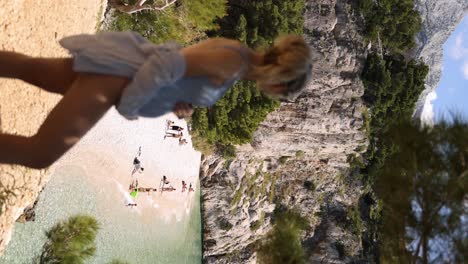 profile view of pregnant woman in swimwear overlooking nugal beach, vertical