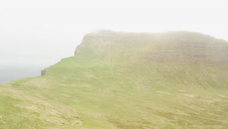 Drone-tracks-towards-mist-covered-nordic-mountain-ridgeline-of-Hornbjarg