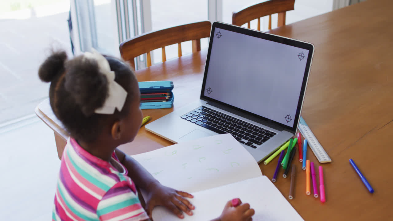 African american girl having online learning at home using laptop with copy space