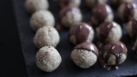 Putting-Melted-Chocolate-To-Cookie-Balls-On-A-Tray-Using-A-Spoon---close-up-slowmo