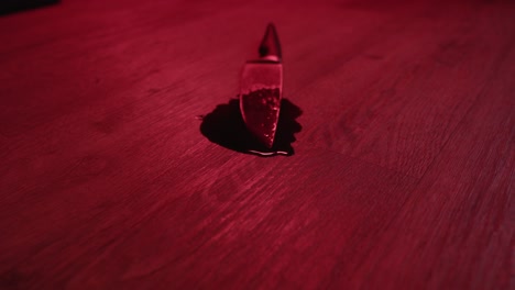 muñeco de un cuchillo de cocina cubierto de sangre en un gran charco de sangre en el piso de la sala de estar