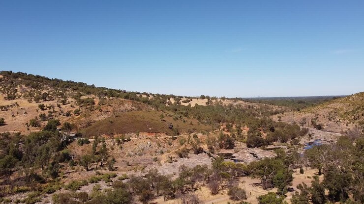 Panoramica lenta a sinistra sopra un letto di fiume roccioso e asciutto, Bells Rapids, fiume Swan, Perth, Australia.