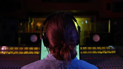 Male-sound-engineer-working-at-a-mixing-desk