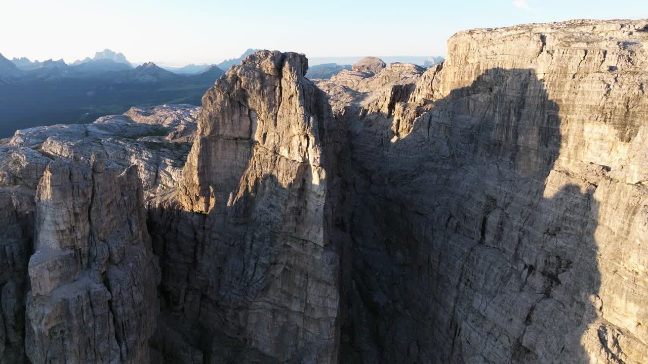 Majestic bird's-eye view of the Dolomites' vast landscapes, with cloud shadows drifting over the rugged terrain, painting a dynamic and ever-changing picture