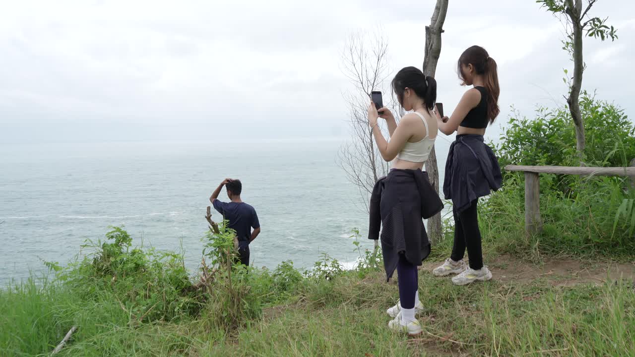 Friends taking pictures of the ocean
