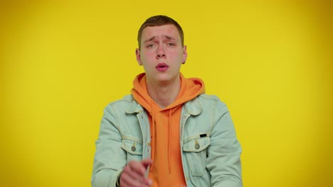 teenager man warning with admonishing finger gesture, saying no, be careful, advice avoid danger