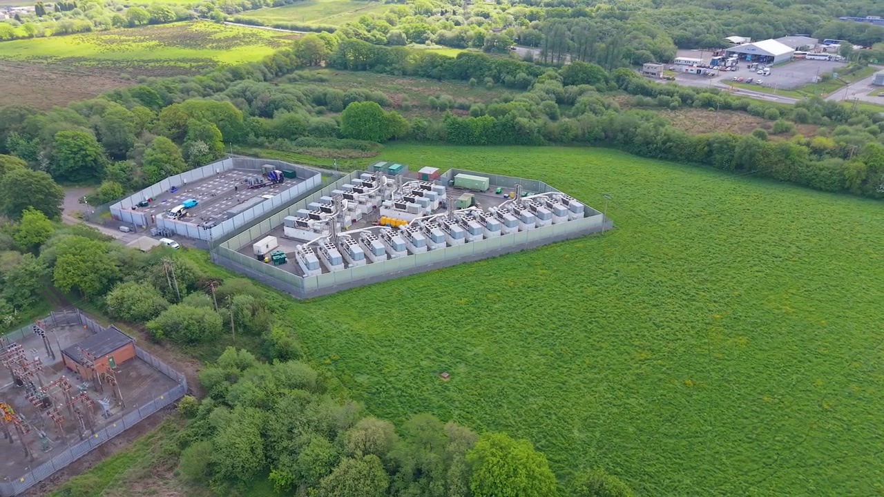 Aerial Perspective of Modern Gas Peaking Plant with exhaust stacks, generators, cooling systems. Rapid-response electricity to the grid during peak demand. BESS Battery Storage under construction. UK.