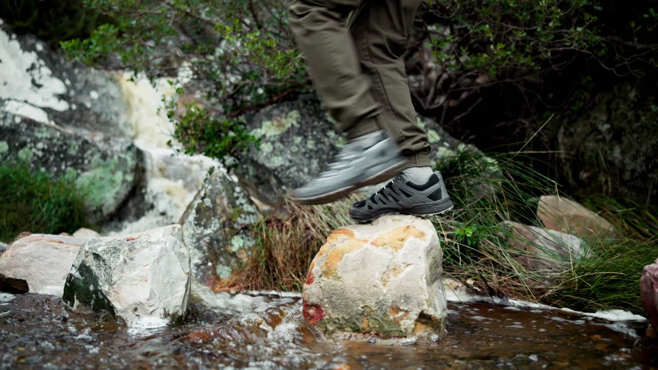 Person hiking across rocks in a stream
