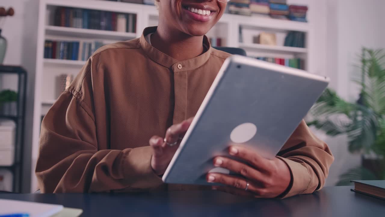 Crop face of young african woman using digital tablet software applications