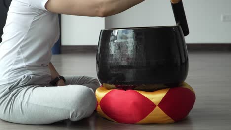 manos de una mujer tocando cuencos de canto tibetano, primer plano