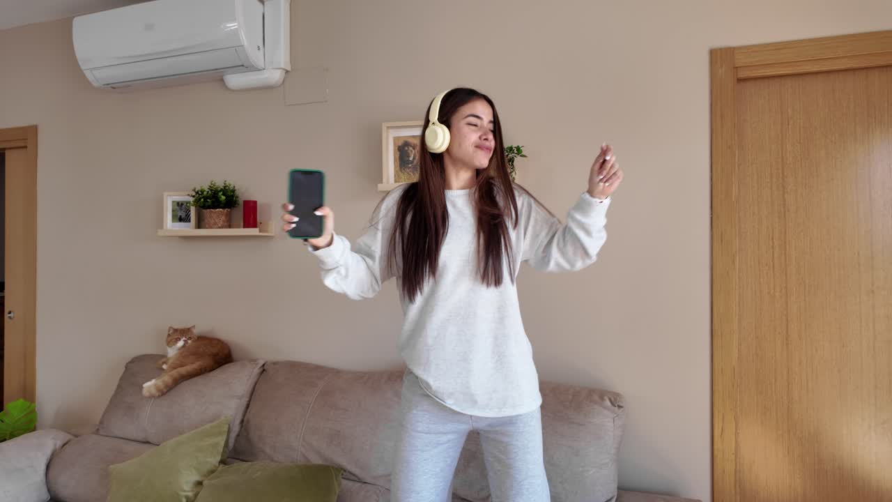 Woman dancing and enjoying music at home