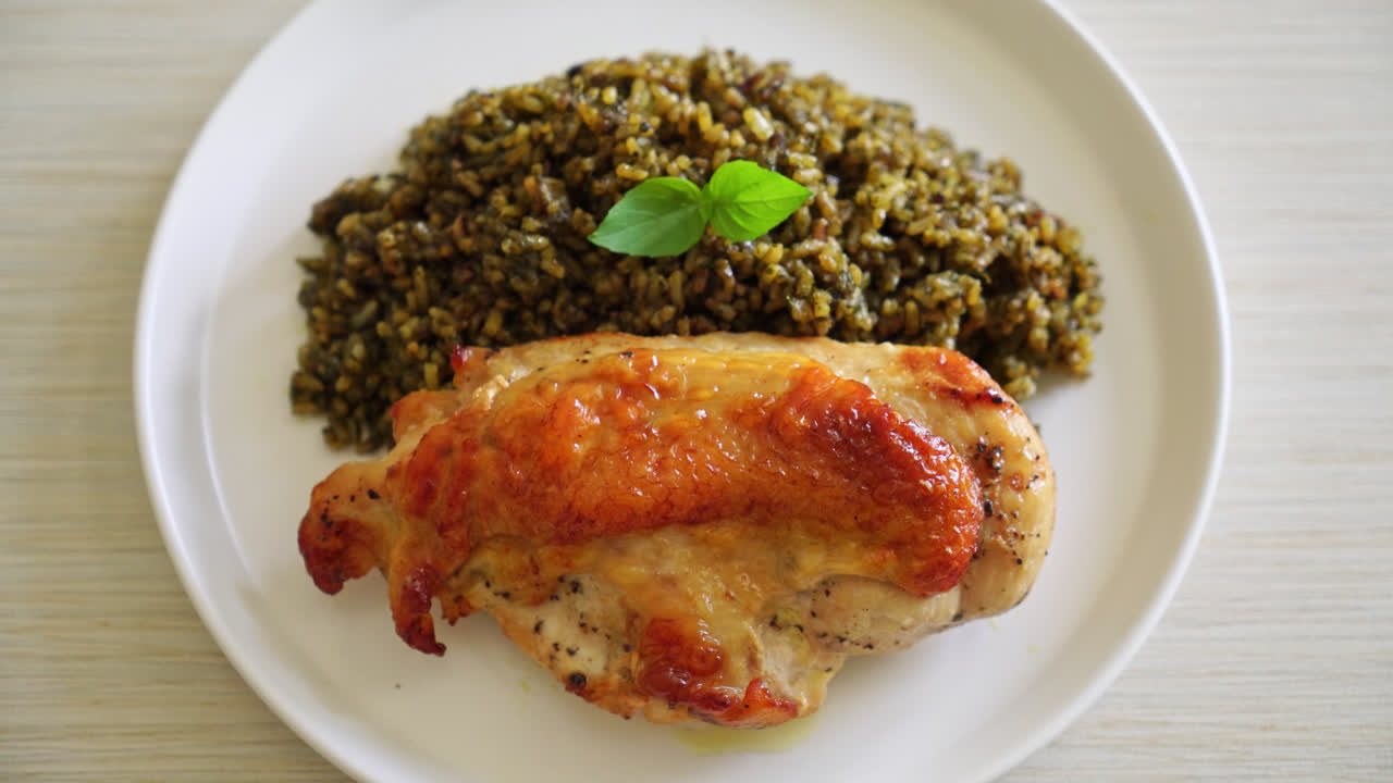 riso fritto al pesto con pollo alla griglia su piatto bianco