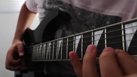 Close-up-of-fingers-moving-along-strings-of-a-guitar