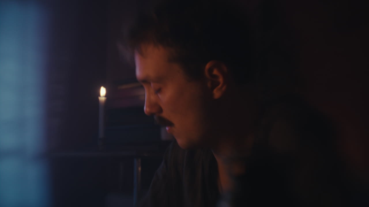 Man Focused by Candlelight
