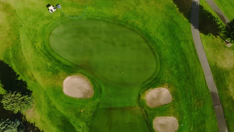 top down drone shot of a golf green with two front green side bunkers