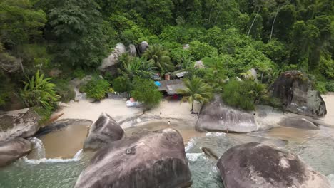 aerial orbit shot of a small turquoise beach in the middle of the atlantic rainforest in angra dos reis, rio de janeiro, brazil