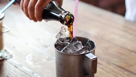 sequence of pouring a drink into an ice-filled cup